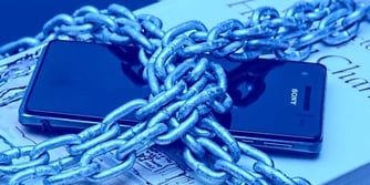 A smartphone wrapped in a thick chain, illustrating the importance of secure storage and key protection for mobile banking and payment apps