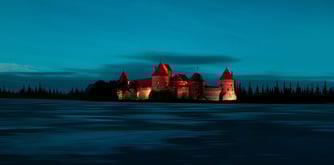 Medieval European castle seen at dusk and illuminated in crimson