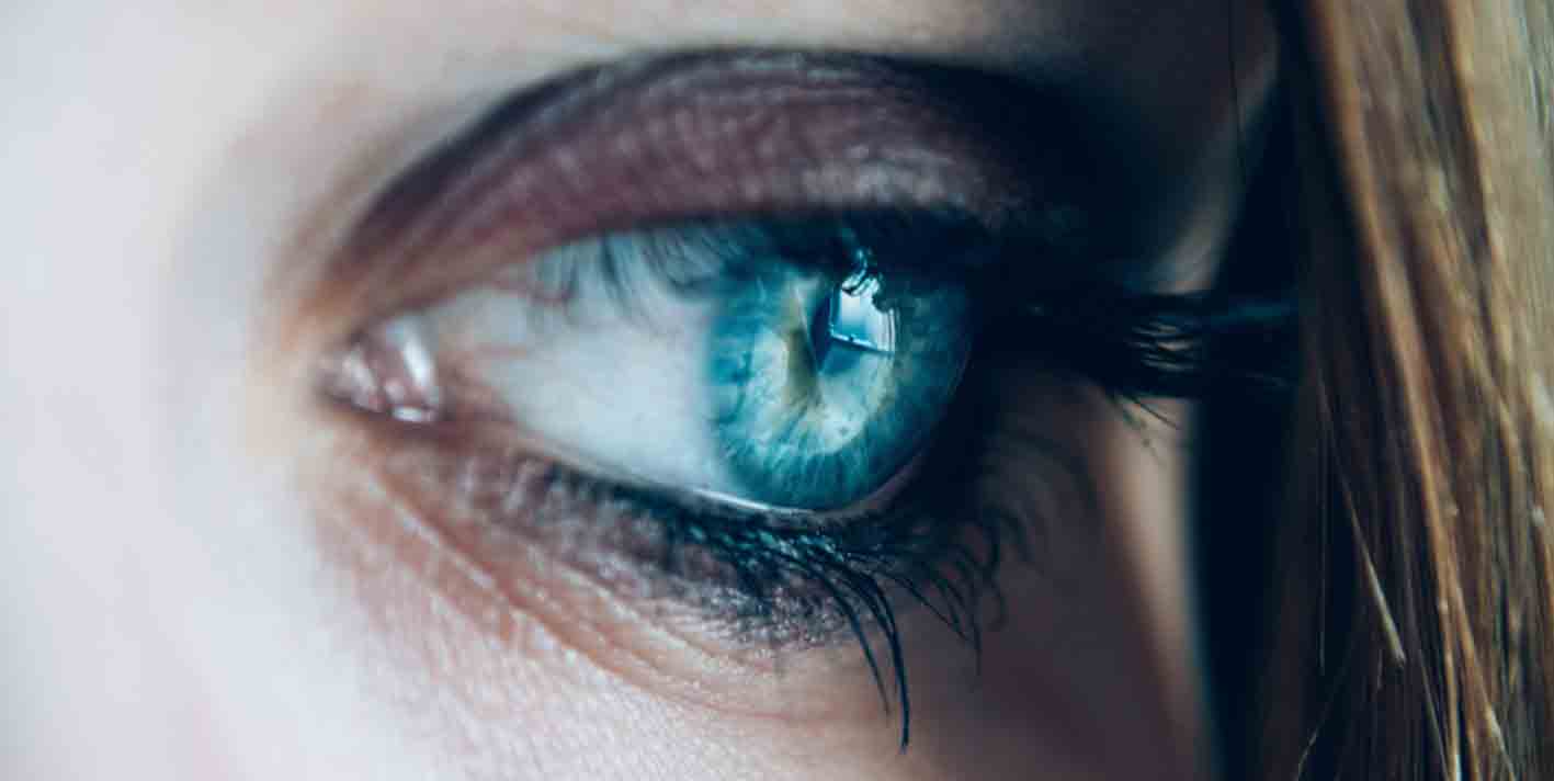 Close up of a bright blue eye, decorated with mascara and eye shadow, representing the concept of what you see is what you sign