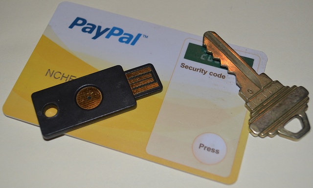 Close up of a traditional door key, a USB stick, and a PayPal card