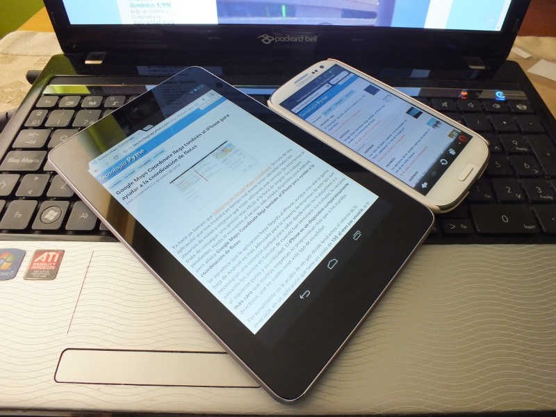 White smartphone and a black tablet lying on an open laptop, being used to research the digital Signature Activation Protocol